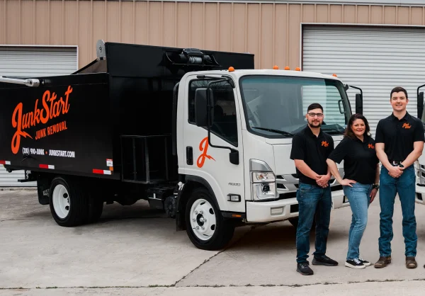 The JunkStart Junk Removal team stands proudly in front of their branded white truck. TITLE